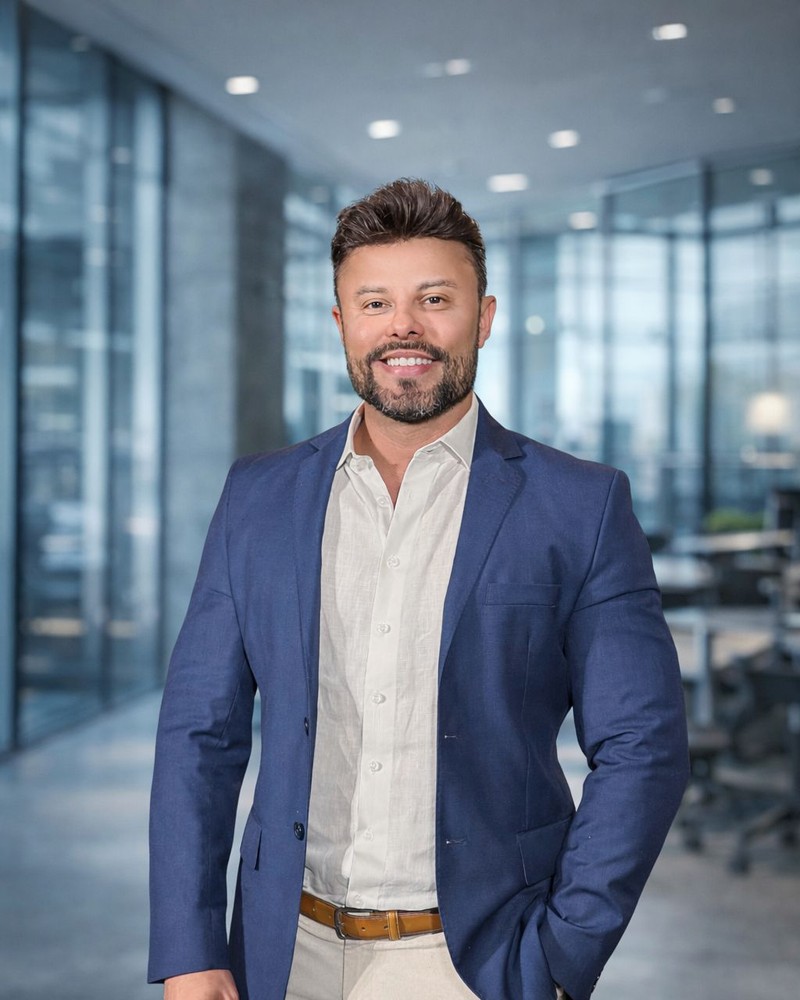 Retrato de Leonardo Oliveira, de blazer marinho e camisa clara, em um escritório.
